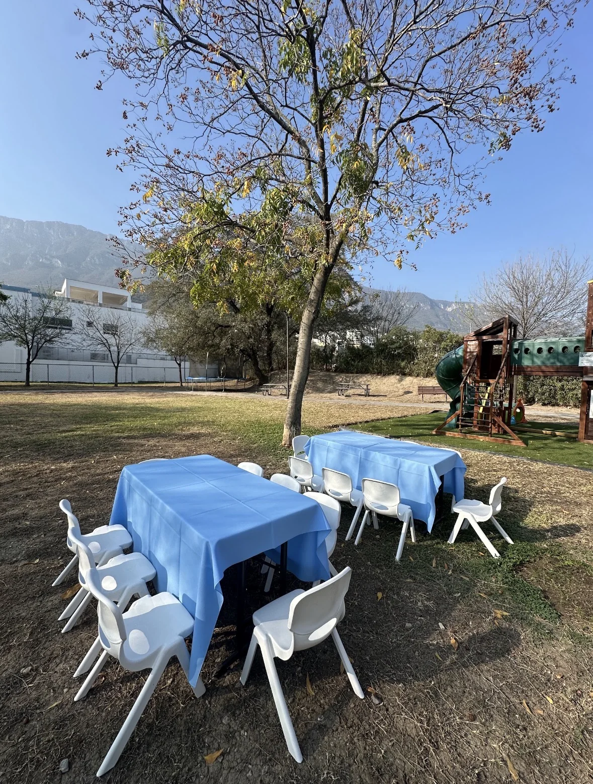 Montaje infantil exterior con mesas azules